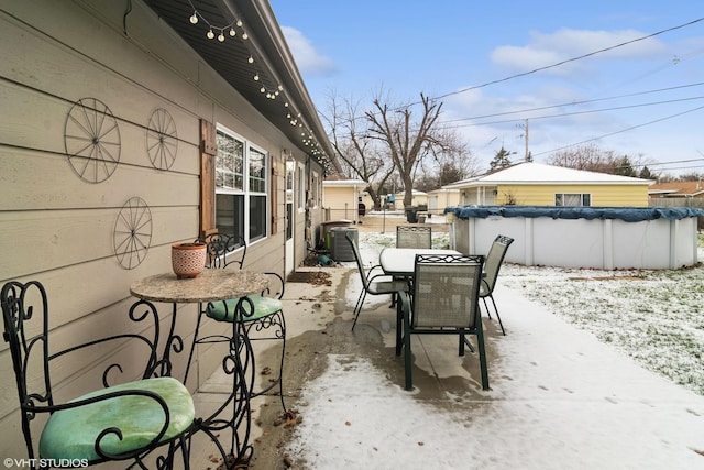 snow covered patio with central AC and a covered pool