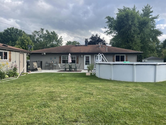 back of property featuring a patio area and a lawn