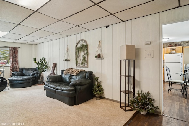 living room featuring hardwood / wood-style floors and a drop ceiling