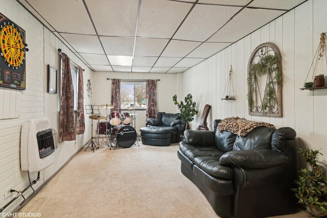 carpeted living room with a paneled ceiling and heating unit