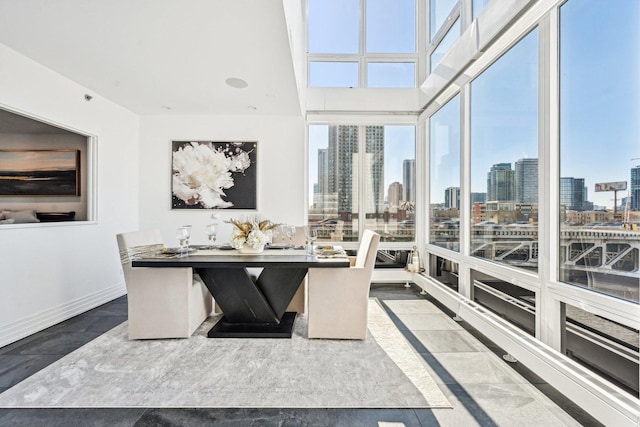 office area with expansive windows, baseboards, and a city view