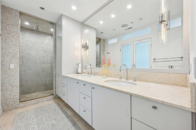 bathroom featuring a sink, double vanity, a shower stall, and tile patterned floors