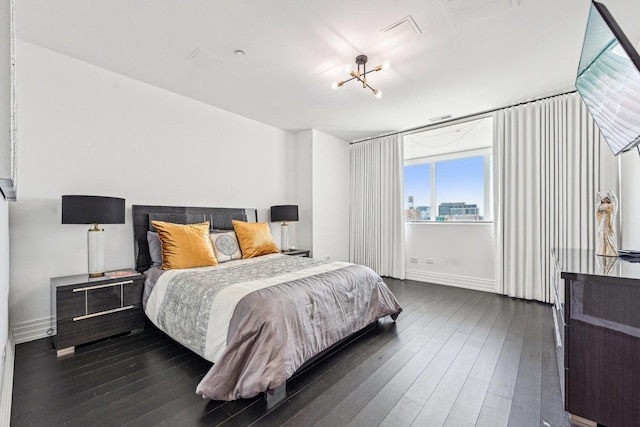 bedroom with baseboards and dark wood-style flooring