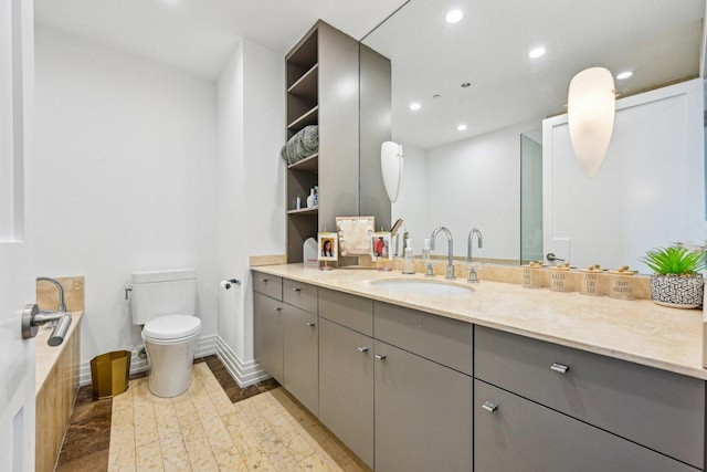 bathroom featuring vanity, wood finished floors, baseboards, recessed lighting, and toilet