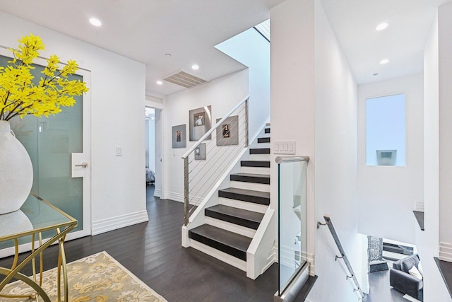 stairs featuring visible vents, recessed lighting, baseboards, and wood finished floors