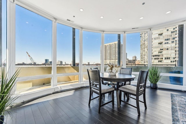 sunroom / solarium featuring visible vents and a city view