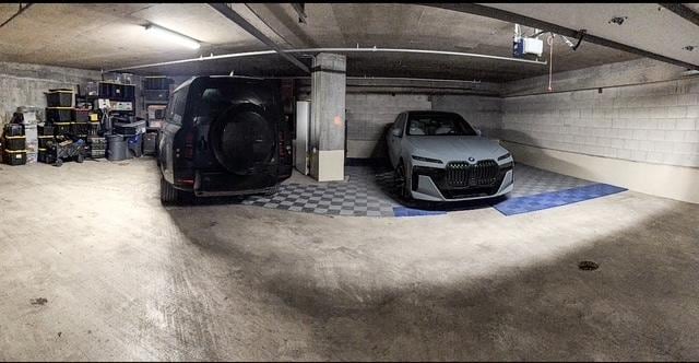 parking deck featuring concrete block wall and a garage door opener