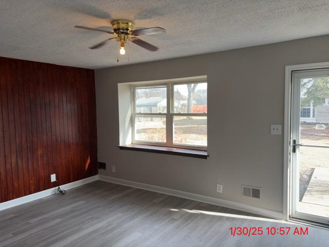 spare room featuring ceiling fan, hardwood / wood-style flooring, and a textured ceiling