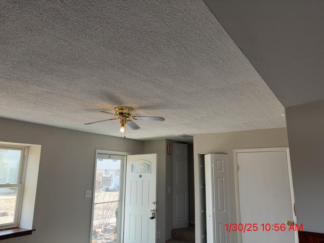 foyer featuring ceiling fan and a textured ceiling