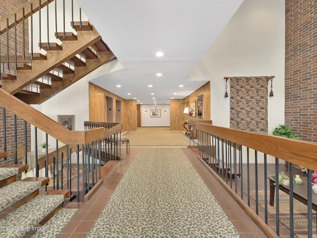 hall with a high ceiling and light tile patterned floors