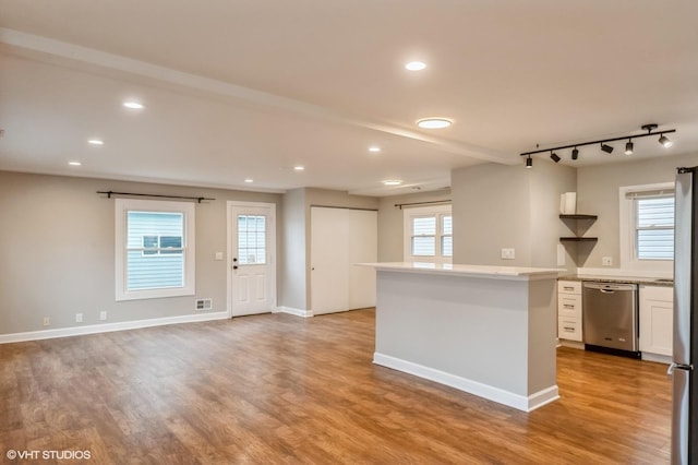 kitchen featuring light countertops, appliances with stainless steel finishes, light wood-type flooring, and white cabinetry