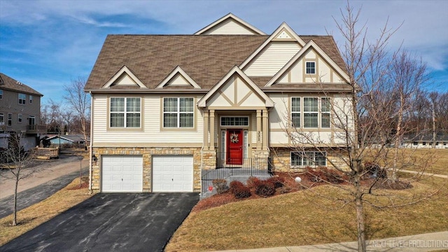 view of front of property featuring aphalt driveway, an attached garage, stone siding, and a shingled roof