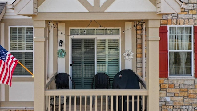 entrance to property featuring stone siding and stucco siding