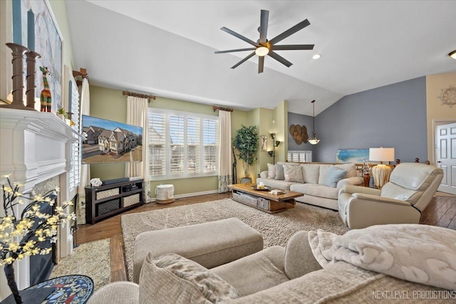 living room with lofted ceiling, wood finished floors, a high end fireplace, and ceiling fan