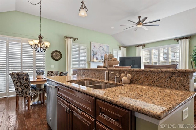 kitchen with stainless steel dishwasher, lofted ceiling, a kitchen island with sink, and a sink