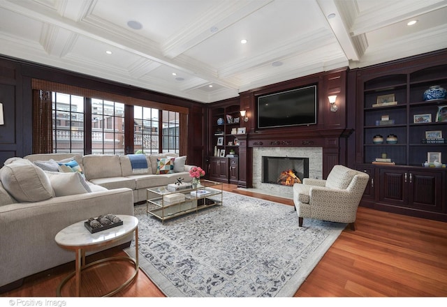 living room with coffered ceiling, beam ceiling, wood finished floors, and crown molding