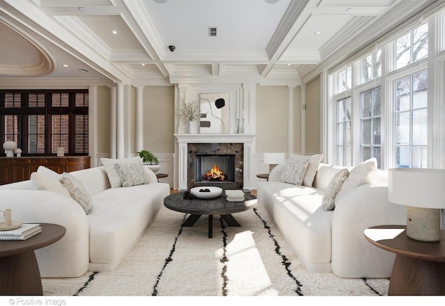 living area featuring crown molding, coffered ceiling, a decorative wall, and beamed ceiling