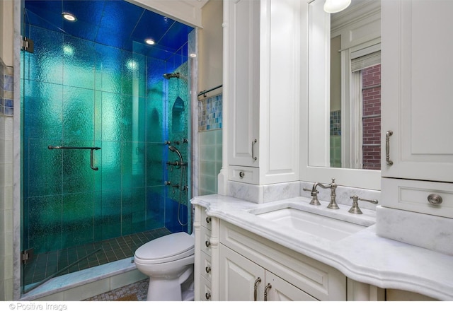 full bathroom with toilet, vanity, and a stall shower