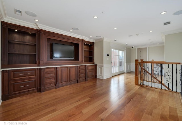 unfurnished living room featuring light wood finished floors, wainscoting, ornamental molding, and recessed lighting