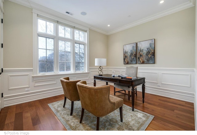 home office featuring crown molding, visible vents, a wainscoted wall, and wood finished floors