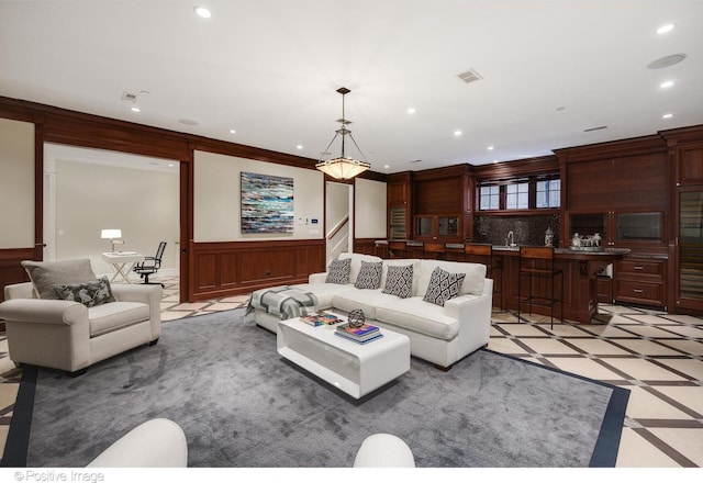 living area with indoor wet bar, visible vents, wainscoting, ornamental molding, and recessed lighting