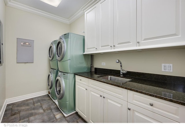 laundry area with stacked washer / drying machine, a sink, cabinet space, baseboards, and ornamental molding