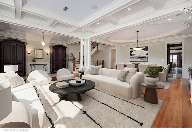 living room featuring ornate columns, coffered ceiling, beam ceiling, crown molding, and light wood-style floors