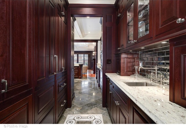 bar featuring tasteful backsplash, crown molding, and a sink
