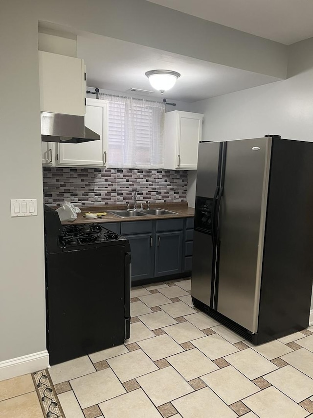 kitchen featuring black gas range oven, ventilation hood, sink, white cabinets, and stainless steel fridge with ice dispenser