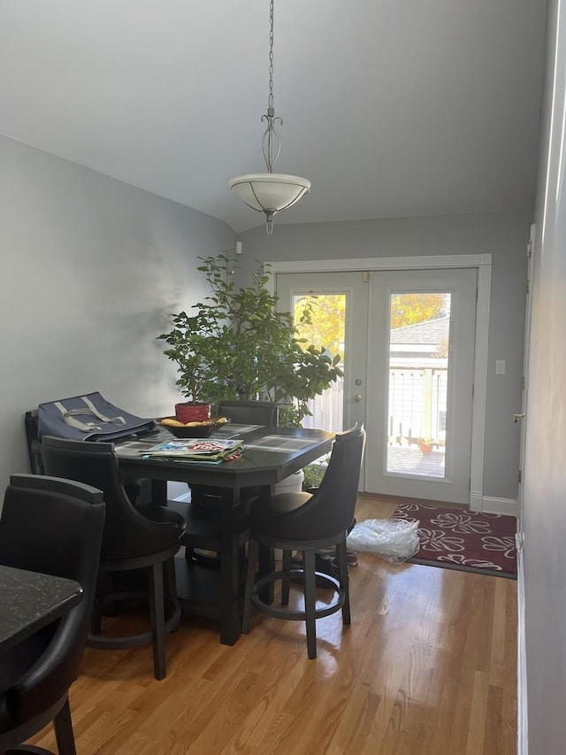 dining area featuring hardwood / wood-style flooring, lofted ceiling, and french doors