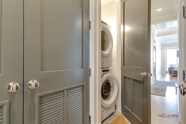 laundry room with stacked washer and dryer, laundry area, and recessed lighting