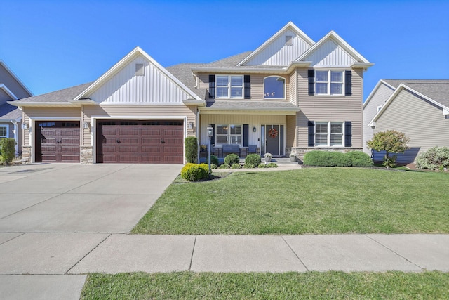 view of front of house featuring a garage, covered porch, and a front lawn