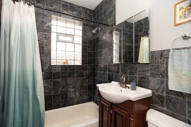 full bathroom with tile walls, toilet, vanity, and shower / bath combo with shower curtain