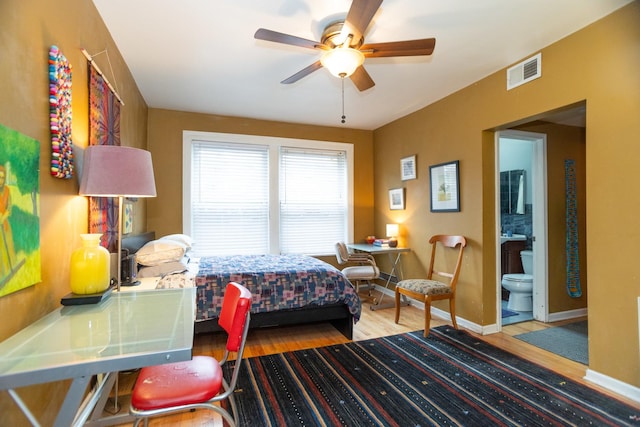 bedroom with hardwood / wood-style floors, connected bathroom, and ceiling fan