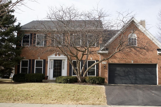 colonial house with a garage and a front yard