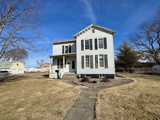 view of front facade featuring a porch, a detached garage, and a front yard