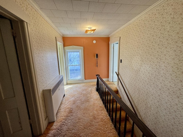 hall featuring light carpet, ornamental molding, radiator heating unit, and wallpapered walls