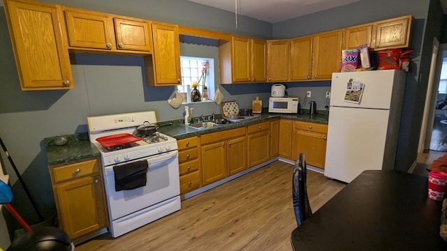 kitchen with white appliances, sink, and light hardwood / wood-style floors