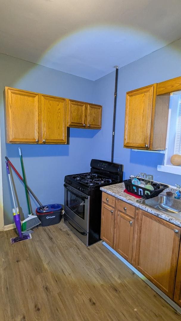 kitchen featuring gas range, sink, and light wood-type flooring