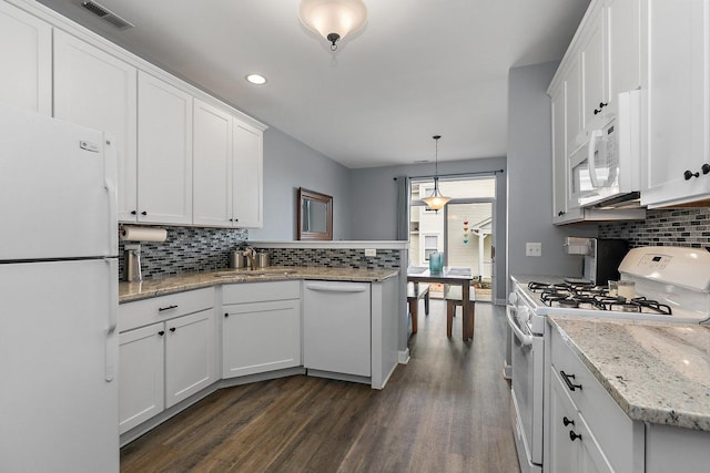 kitchen with dark hardwood / wood-style floors, pendant lighting, backsplash, white cabinets, and white appliances