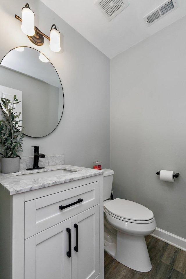 bathroom with vanity, toilet, and wood-type flooring