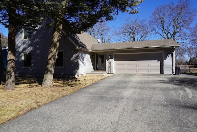 view of front of property with driveway, a garage, and roof with shingles