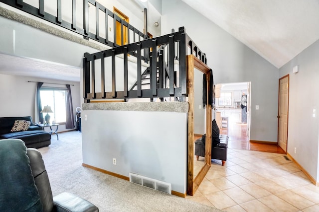 stairs with baseboards, high vaulted ceiling, visible vents, and tile patterned floors