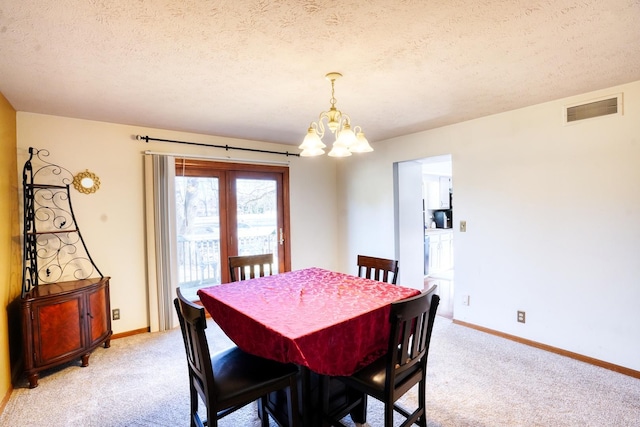 dining room featuring visible vents, an inviting chandelier, light carpet, a textured ceiling, and baseboards