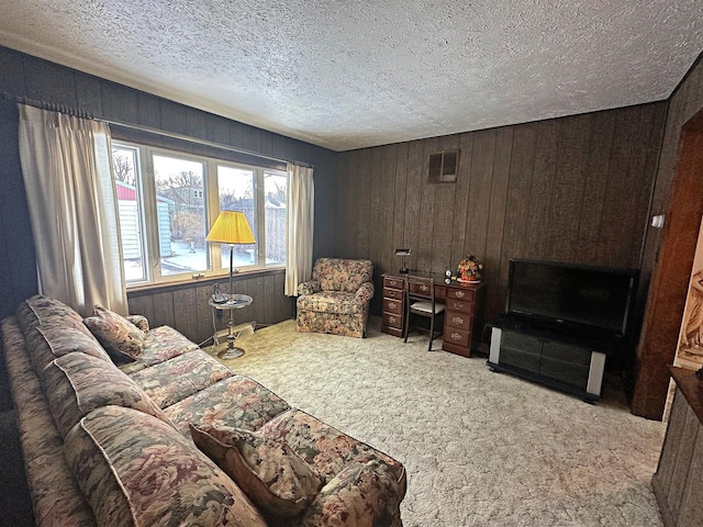 living area with wooden walls, light carpet, and a textured ceiling