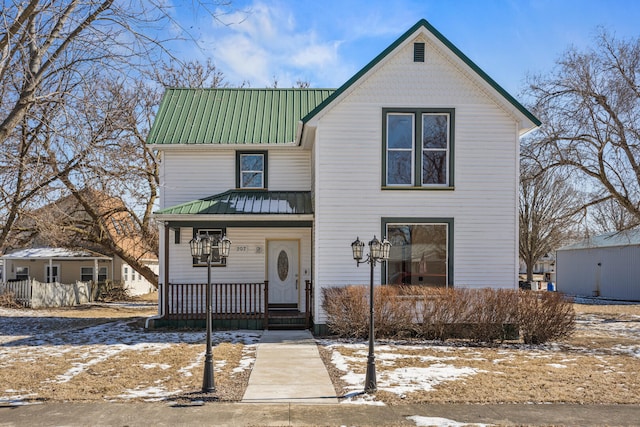 traditional-style house featuring metal roof and a porch