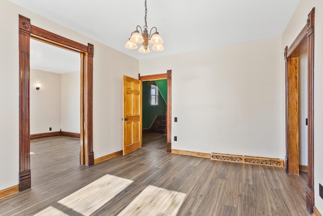 unfurnished dining area with a notable chandelier, dark wood finished floors, stairway, and baseboards