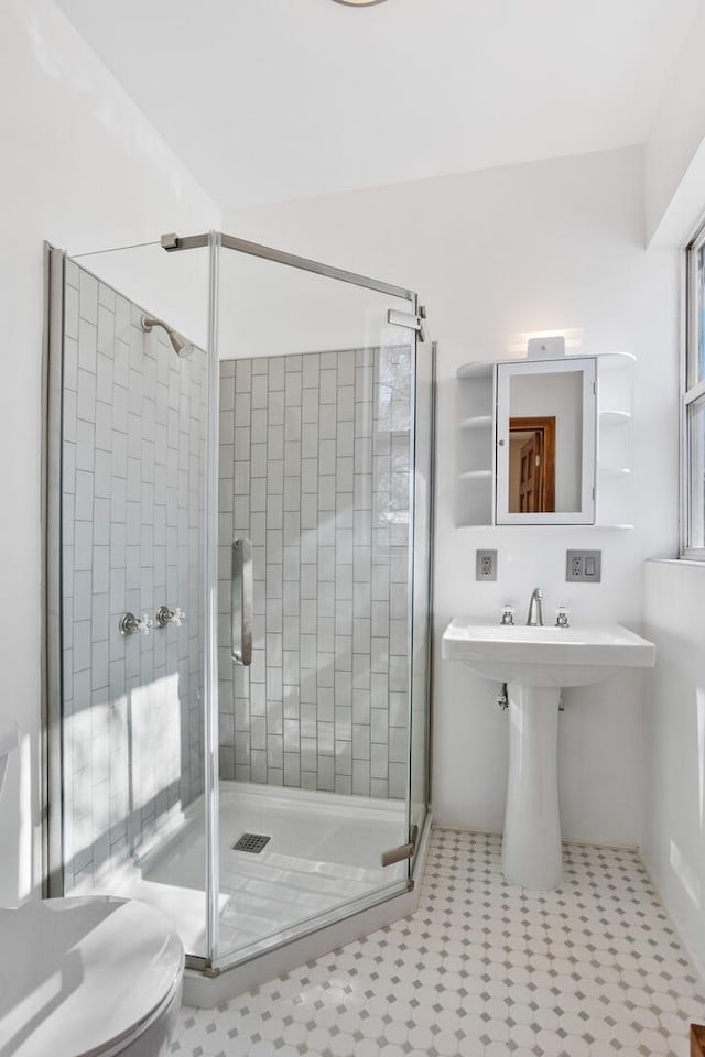 bathroom with toilet and a stall shower