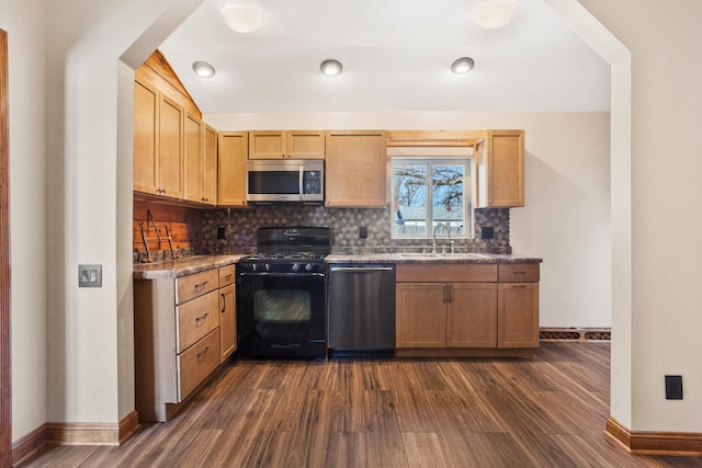 kitchen featuring dark wood-style flooring, a sink, baseboards, appliances with stainless steel finishes, and backsplash