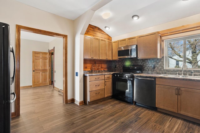 kitchen with dark wood-style floors, black appliances, tasteful backsplash, and a sink